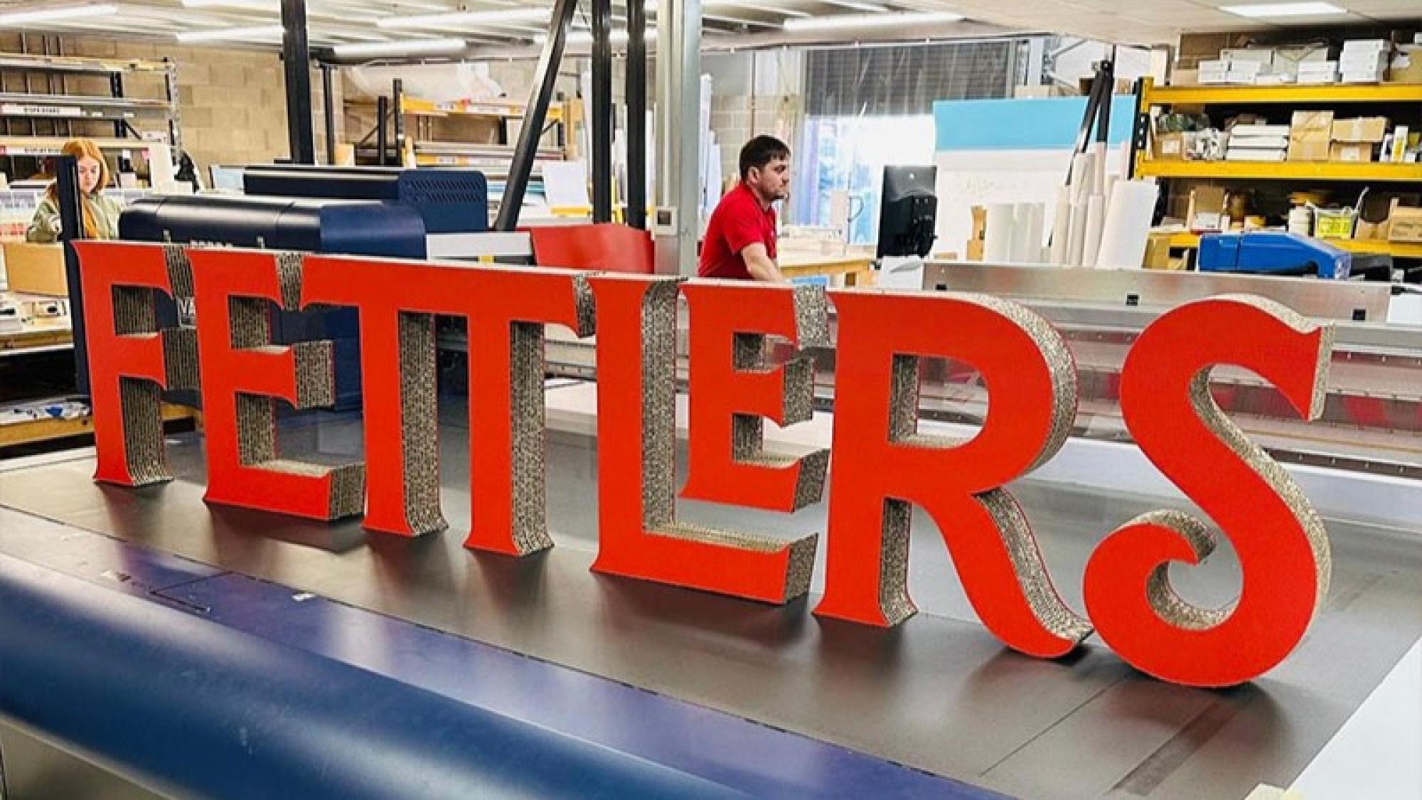 Large red cut out letters that spell Fettlers 